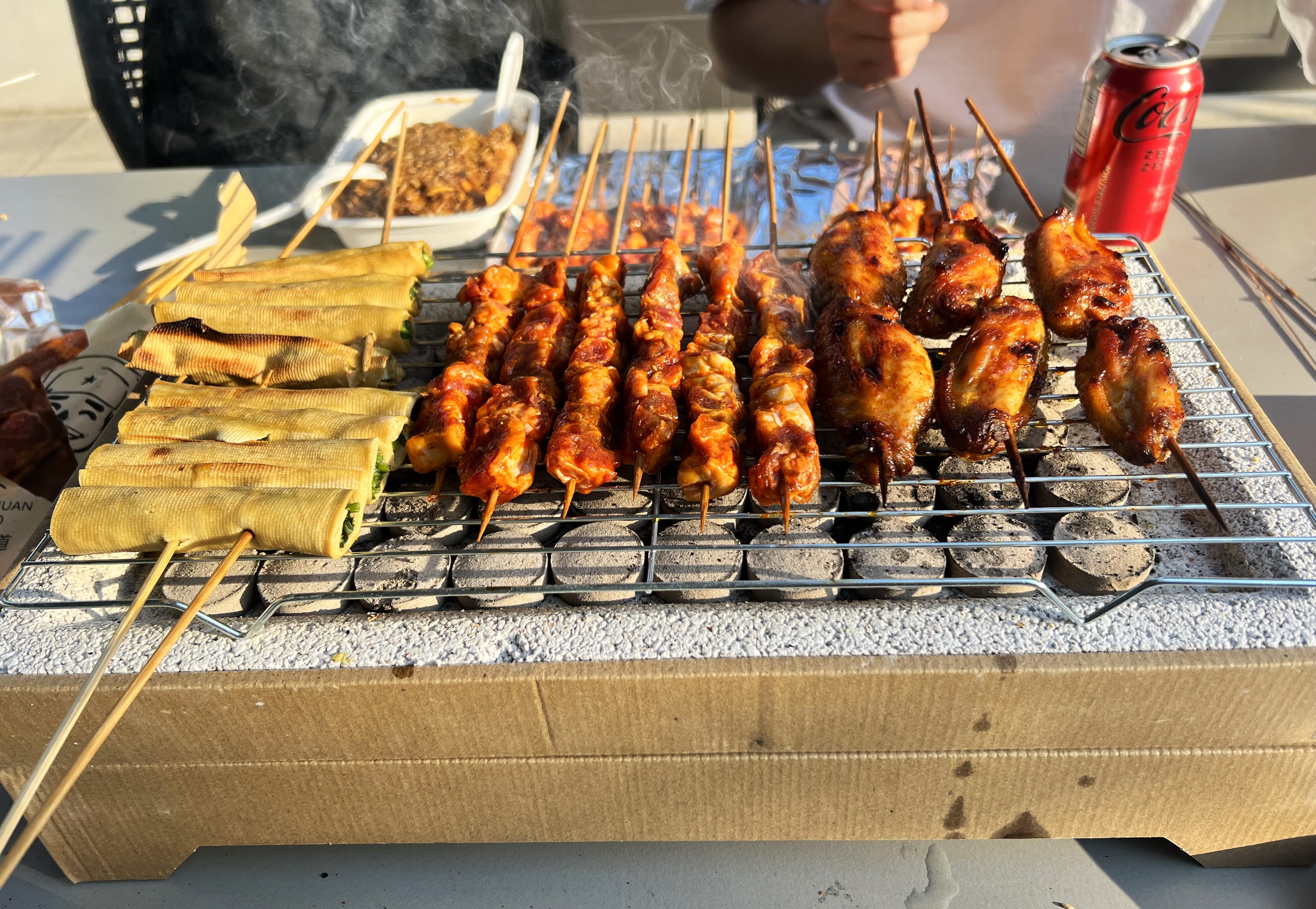 Skewers and vegetables cooking on an EasyBBQ grill outdoors